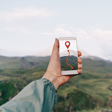 Traveler man holding smartphone in a hand and using GPS app, pov